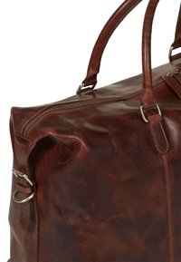 Hnědá kožená cestovní taška s texturovaným povrchem, horním zipem a dvojitými uchy. Obsahuje kovové kování a jemný lesk.