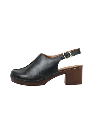 Zapato slingback de cuero negro con tacón grueso marrón, correa ajustable con hebilla y detalle de suela cosida.