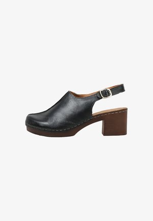 Zapato slingback de cuero negro con tacón grueso marrón, correa ajustable con hebilla y detalle de suela cosida.