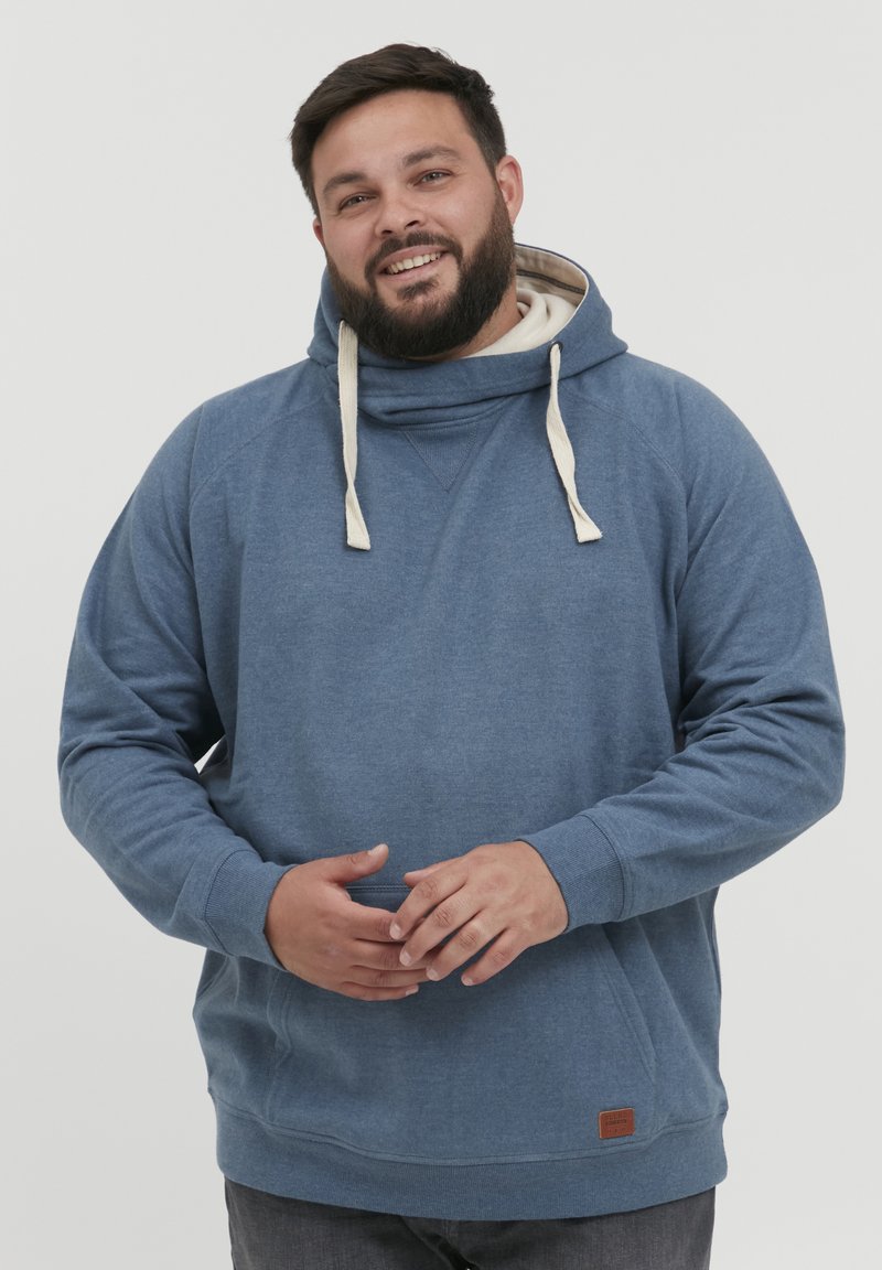 Sudadera azul de tela suave, con cuello alto y cordones, puños acanalados y un pequeño parche del logo en la parte inferior izquierda.