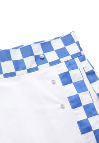 Jupe avec ceinture et bordure latérale à carreaux bleus et blancs, décorée de trois boutons imitation perle sur tissu blanc.