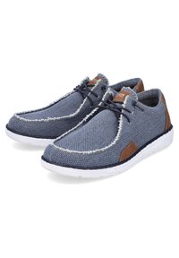 Baskets décontractées bleues avec semelles blanches texturées, accents en cuir marron et lacets noirs, présentées en paire légèrement tournées vers la droite.
