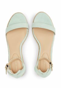 Sandali in suede verde menta chiaro con una larga fascia sul piede, cinturino alla caviglia e tacco avvolto in juta naturale, dotati di una soletta beige liscia.