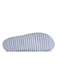 Suola di scarpa in gomma, grigio chiaro, con una texture caratterizzata da scanalature orizzontali e bordi arrotondati. Include loghi circolari vicino al fondo e ai lati. Prodotta in Italia.