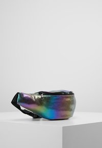 Holografisk bæltetaske med lynlås, der har et glat, reflekterende materiale i sort, sølv og regnbuefarver. Justerbar rem vedhæftet.