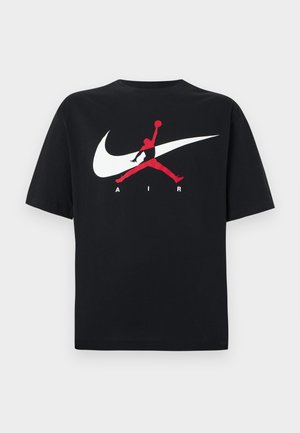 Μαύρο βαμβακερό μπλουζάκι με στρογγυλή λαιμόκοψη, με μεγάλο λευκό λογότυπο Nike swoosh και κόκκινο λογότυπο Jumpman μαζί με το κείμενο "AIR" σε λευκό χρώμα.