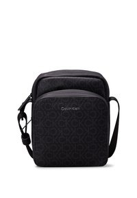 Borsa nera Calvin Klein con superficie testurizzata, motivo a logo CK in rilievo, forma rettangolare e tracolla regolabile.