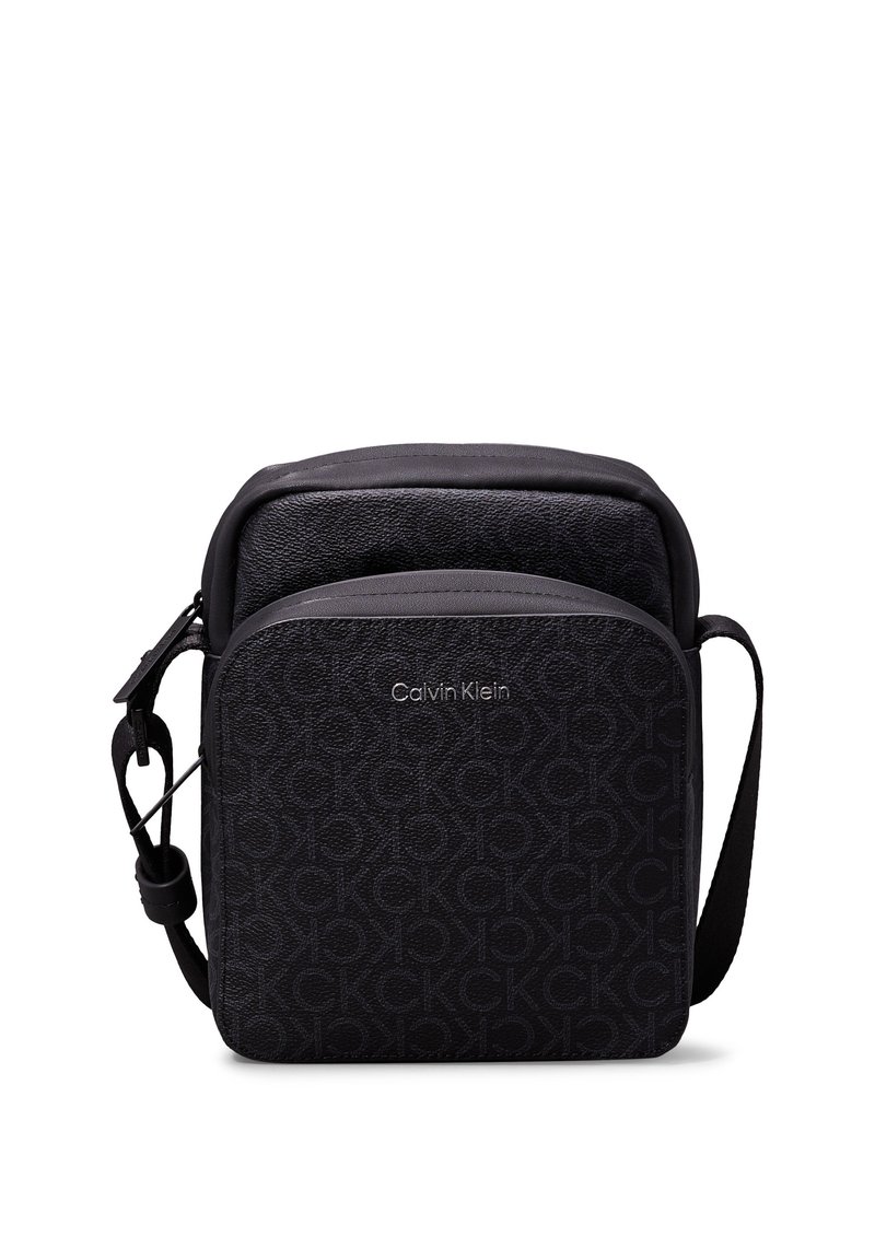 Borsa nera Calvin Klein con superficie testurizzata, motivo a logo CK in rilievo, forma rettangolare e tracolla regolabile.