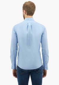 Jasnoniebieska koszula z długimi rękawami, z plisą z tyłu i zapinanymi mankietami. Wykonana z gładkiego materiału, prezentująca klasyczny krój kołnierzyka.