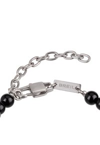 Pulsera de cadena de plata con cuentas negras y un cierre rectangular grabado con "BREIL" sobre un fondo blanco.