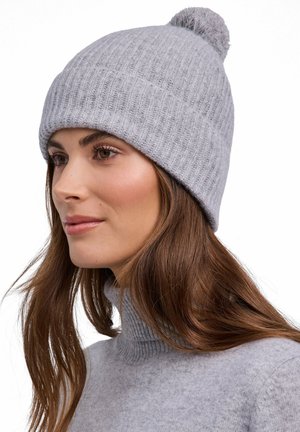Bonnet gris côtelé en maille avec un pompon sur le dessus. Fabriqué à partir d'un matériau doux et texturé, il présente un design retroussé pour un ajustement confortable.