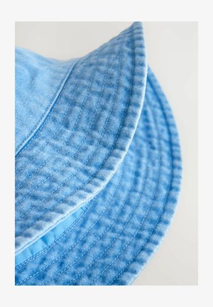 Fénykék denim sapka széles karimával, látható varrási részletekkel és texturált szövet felülettel.