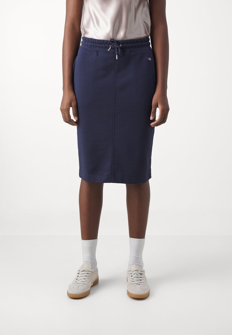 Granatowa spódnica midi wykonana z miękkiego materiału, z elastycznym paskiem w talii i sznurkiem do regulacji oraz bocznymi kieszeniami. Minimalistyczny design z płaskimi szwami.
