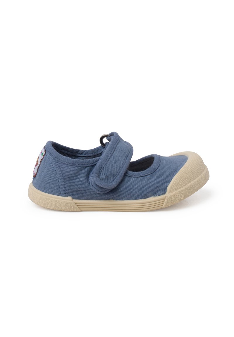 Zapato Mary Jane de lona azul con tira de Velcro, suela de goma beige, punta redonda y un pequeño parche colorido en el talón.