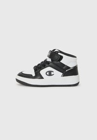 Des baskets montantes noir et blanc présentent une conception à lanière et à lacets, avec le logo Champion visible sur le côté.