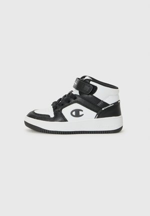 Sorte og hvide høje sneakers har en rem og snørebåndsdesign, med Champion-logoet synligt på siden.