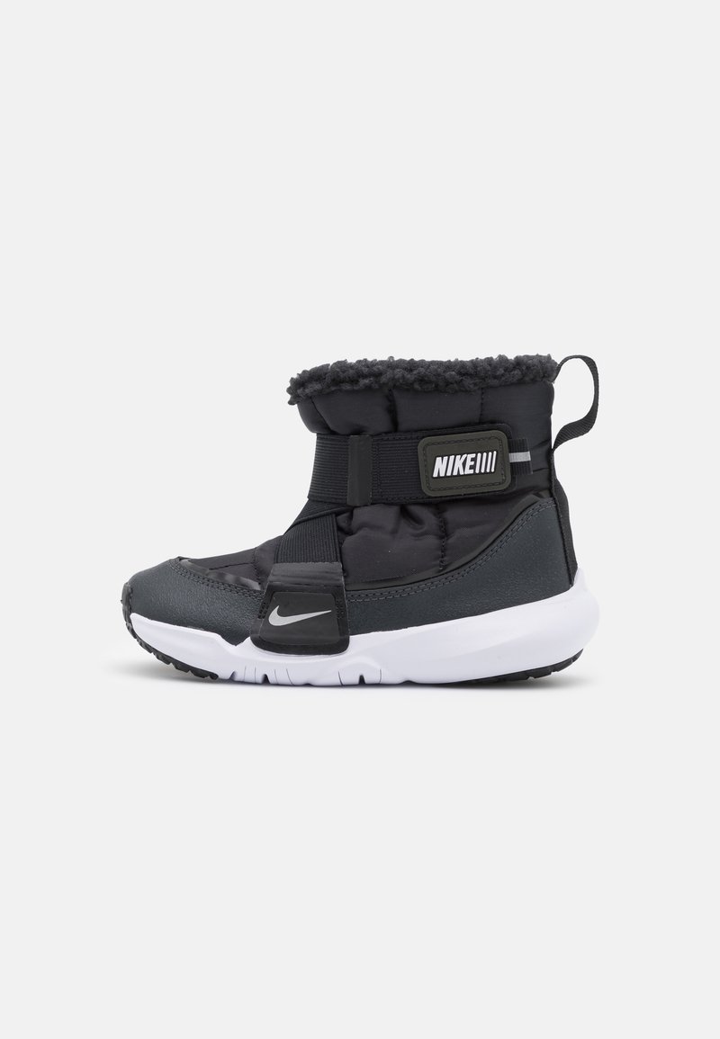 Botte d'hiver Nike noire et grise avec semelle blanche, tige rembourrée, sangle ajustable, doublure en shearling et languette au talon.