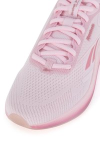 Világos rózsaszín sportcipő, hálós felsőrésszel, lapos fűzőkkel és párnázott talppal, amelyen gradációs hatás látható. A Reebok logó a nyelvén látható.