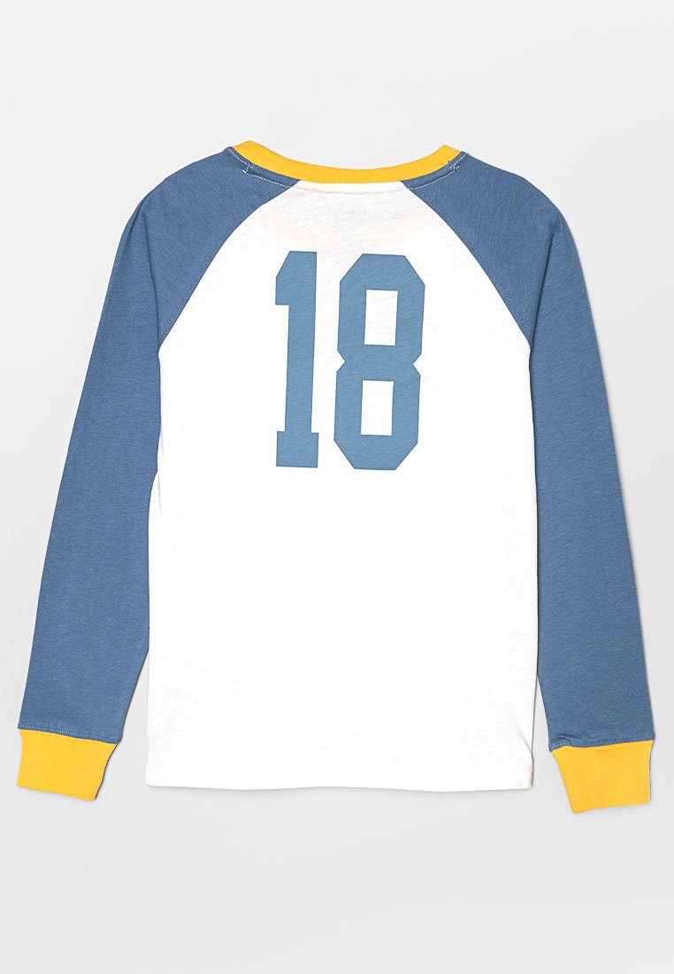 Maglietta a maniche lunghe con maniche raglan blu, corpo bianco, colletto giallo e numero "18" di grandi dimensioni stampato sul retro.