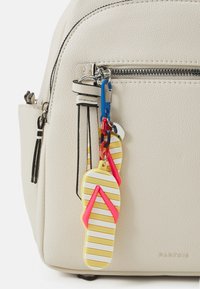 Beige faux läder ryggsäck med zippered framficka, prydd med en färgglad flip-flop charm i gult, rosa och vita accent.