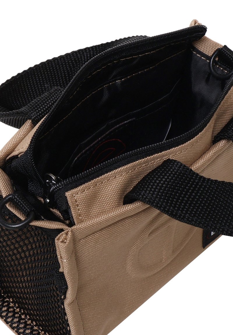 Khakifarbene Stofftasche mit schwarzen Akzenten, ausgestattet mit einem Reißverschluss und mehreren Fächern. Strukturierter Stoff mit einer netzartigen Seitentasche.