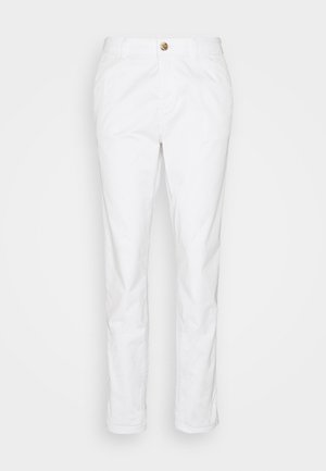 Białe, dopasowane spodnie z przodu zapinane na guzik i zamek błyskawiczny, z pętlami na pasek oraz subtelnymi przednimi kieszeniami, prezentowane na jednolitym tle.