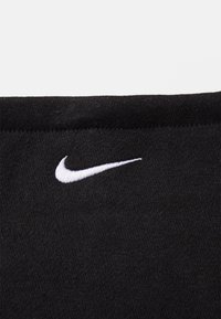 Juodas audinys su lygiu paviršiumi, ant viršutinio kairiojo krašto išsiuvinėtu baltu Nike logotipu. Stačiakampio formos su švariais kraštais.