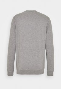 Sudadera gris con mangas largas, puños y dobladillo acanalados. Presenta una textura simple y lisa y un diseño clásico de cuello redondo.