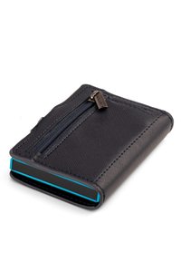 Cartera texturizada de color azul marino con un compartimento con cremallera, diseño elegante y un borde acentuado en turquesa. Fabricada con material duradero.