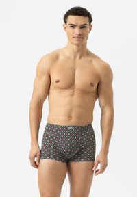 Patroon boxershorts op een donkere achtergrond, met een geometrisch ontwerp met rode en witte accenten. Gemaakt van een zachte stof.