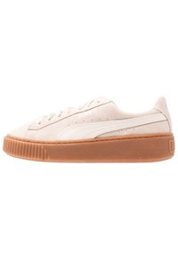 Baskets en suédine Puma de couleur beige clair, avec un dessus texturé, une bande blanche sur le côté et une épaisse semelle en caoutchouc gomme avec des accents striés.