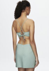 Mintgrøn to-delt sæt med en cropped top med justerbare krydsrygsstropper og en tætsiddende mini-skjørt med lynlås.