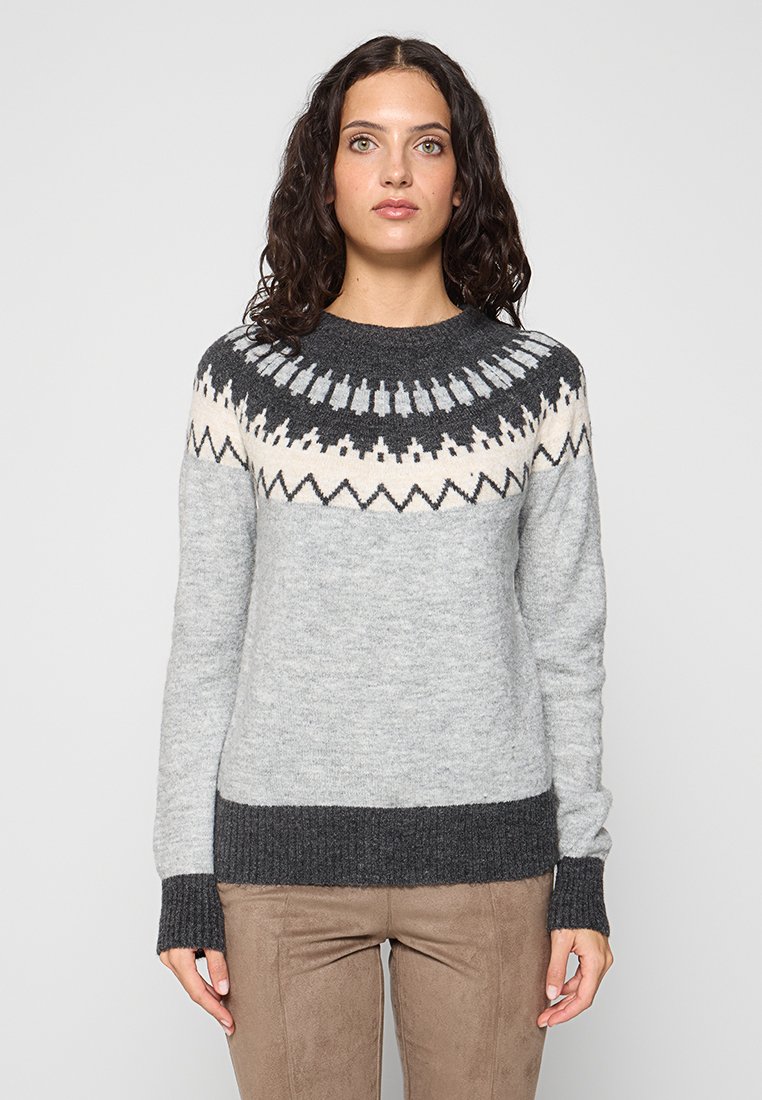 Szary sweter dzianinowy z wzorzystym karczkiem w czarne, białe i jasnoszare motywy. Ściągacze przy mankietach i u dołu w ciemniejszym szaro.