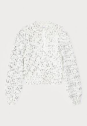 Hvid strikket trøje med sorte pletter, cropped design, høj hals og lange, puffede ærmer med ribbede manchetter. Teksturområde.