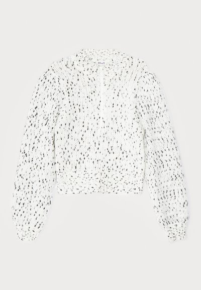 Weißer gestrickter Pullover mit schwarzen Sprenkeln, cropped Design, hohem Kragen und langen, puffigen Ärmeln mit gerippten Bündchen. Strukturiertes Material.