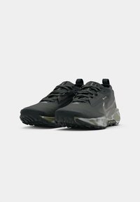 Melnas un pelēkas taku skriešanas kurpes ar strukturētām zolēm, ar auklām, ar cilpām uz papēžiem un ar "GORE-TEX" etiķeti sānos.