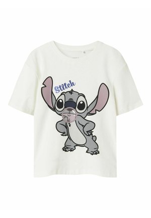 Weißes Baumwoll-T-Shirt mit einer Cartoonfigur, Stitch, der große Ohren hat und einen verspielten Ausdruck zeigt, sowie blauem Text darüber.