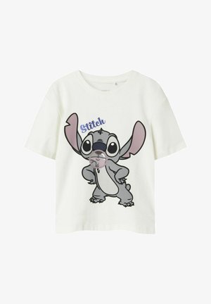 Valge puuvillane t-särk, millel on joonistuskarakter Stitch, kellel on suured kõrvad, mänguline ilme ja sinine tekst üleval.