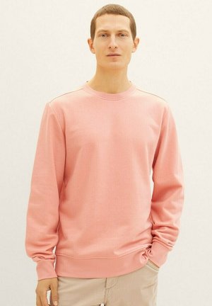 Jasnoróżowy sweatshirt wykonany z miękkiego materiału, z okrągłym dekoltem i długimi rękawami z ribbowymi mankietami, zaprojektowany w luźnym kroju.
