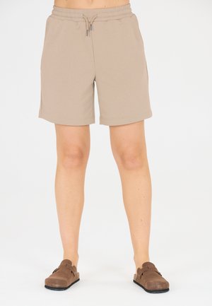 Beige bomulds shorts med elastisk talje og snøre, med sidelommer og lige snit. Bæres med brune slipsko.