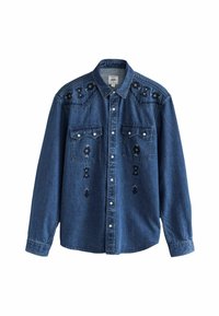 Camisa de denim en azul oscuro con adornos de tachuelas negras y plateadas, presenta dos bolsillos en el pecho, cuello puntiagudo y cierre frontal con botones.