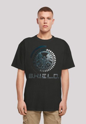 Svart bomullst-skjorte med grafisk design som har et sirkulært emblemet og teksten "S.H.I.E.L.D." i metallisk stil, korte ermer, avslappet passform.
