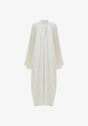 Lange, open voorkimono in licht ivoor, gemaakt van gestructureerde stof met brede mouwen en zijzakken. Glad oppervlak, minimalistisch ontwerp.