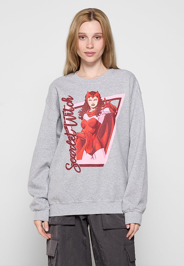 Grå sweatshirt med en stor grafisk tryck av en kvinnlig karaktär i röd klädsel. Ribbad mudd och nederkant, lös passform, mjuk tygtextur.