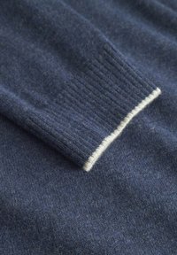 Marineblauer Strickpullover mit geripptem Bündchen und cremefarbener Einfassung. Der Stoff hat eine weiche Textur und bietet ein warmes sowie langlebiges Design.