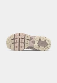Outsole sportske tenisice s teksturiranim dizajnom u nijansama ružičaste i bež, s izraženim uzorcima za prianjanje i elementima amortizacije.