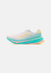 Zapatilla de correr blanca con acentos en amarillo, turquesa y rosa, parte superior de malla transpirable y suela gruesa y acolchada, vista lateral sobre fondo blanco.