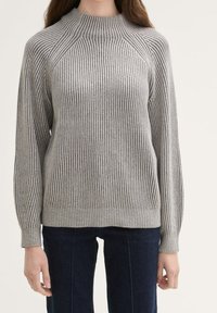 Grijze geribbelde trui met een hoge hals en raglanmouwen. Heeft verschillende streeppatronen en een gestructureerde brei.