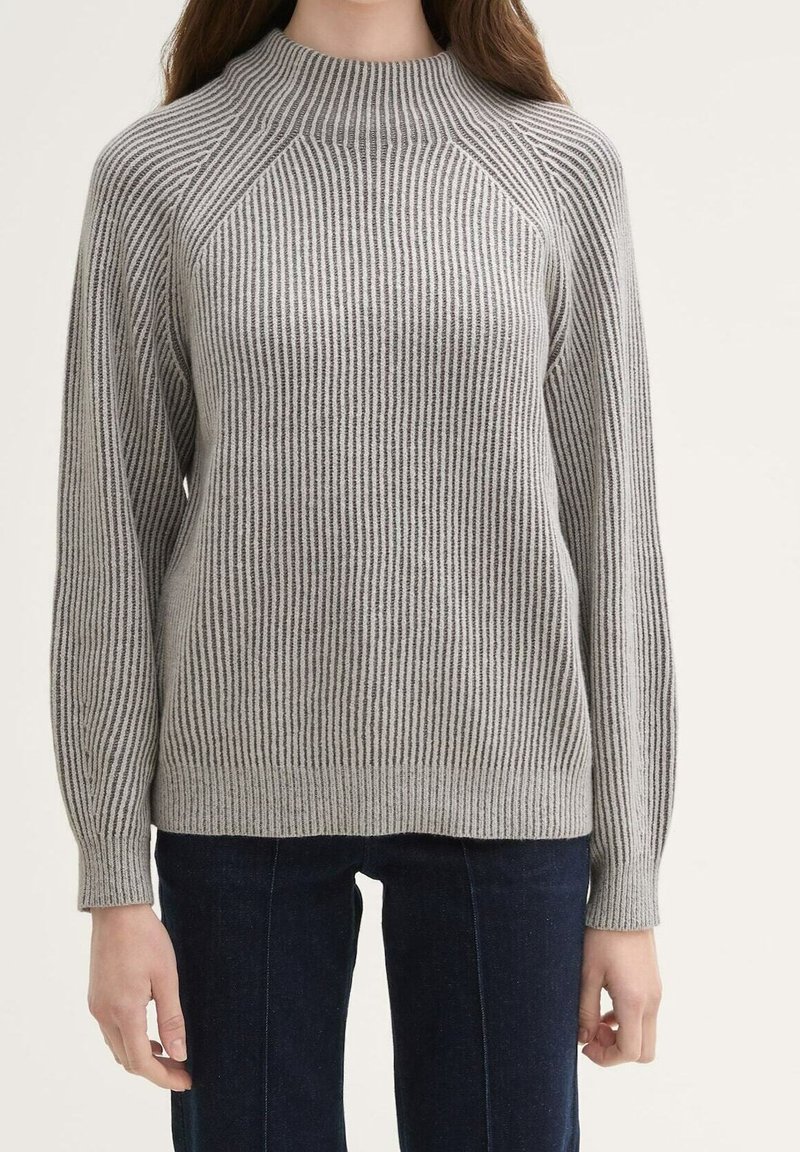 Grijze geribbelde trui met een hoge hals en raglanmouwen. Heeft verschillende streeppatronen en een gestructureerde brei.