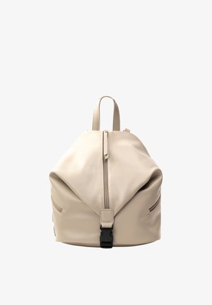 Sac à dos en cuir souple beige avec fermeture éclair centrale, boucle à l’avant, poches latérales zippées et poignée de transport sur le dessus.